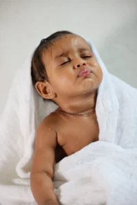 How often should you bathe a newborn: baby wrapped in a towel after bath time