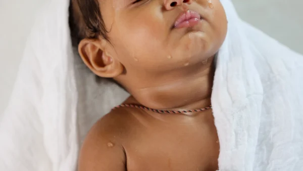 How often should you bathe a newborn: baby wrapped in a towel after bath time