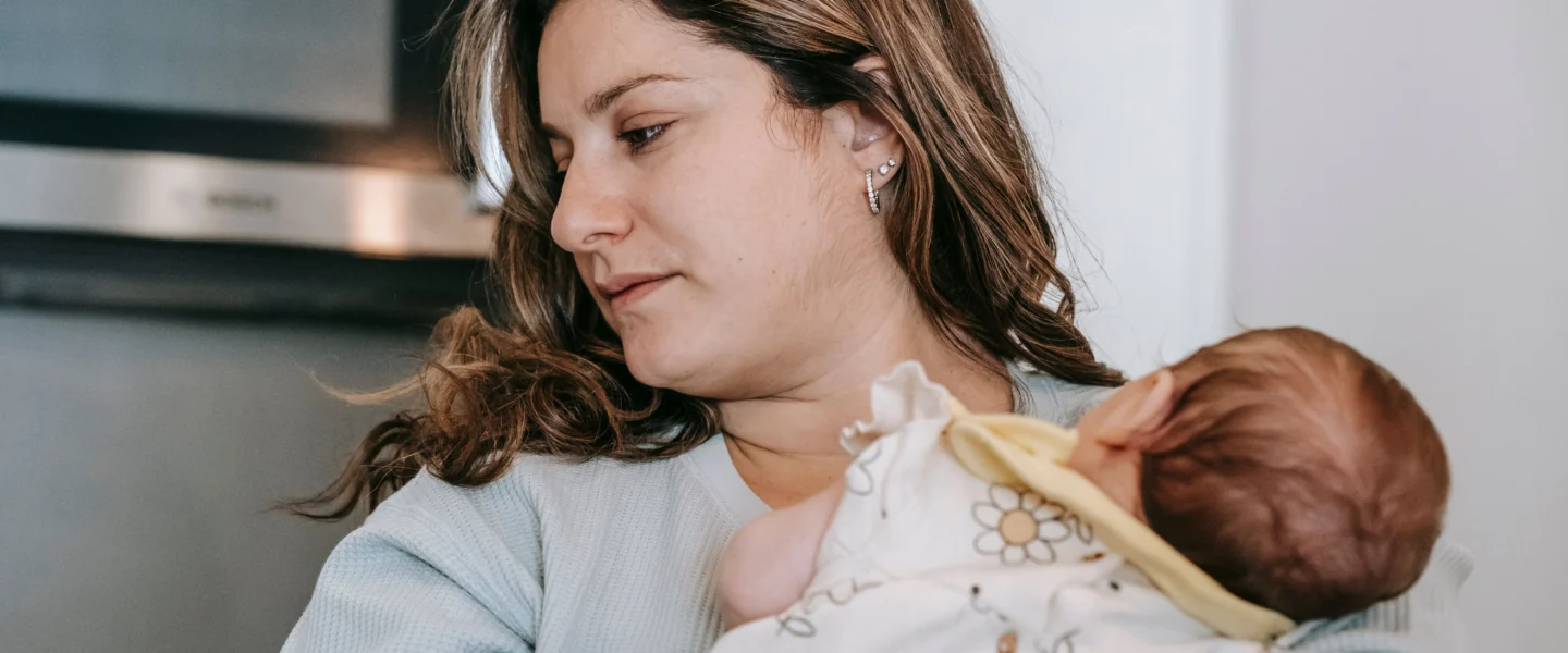 How to burp a baby: parent holding a newborn upright