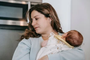 How to burp a baby: parent holding a newborn upright