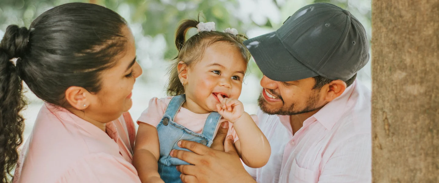 Baby sun protection: parents with a baby outdoors in a sunny park