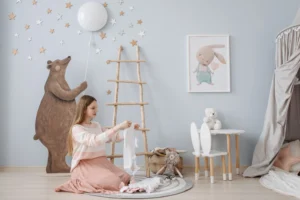 Newborn clothing checklist: parent organizing baby clothes in a nursery