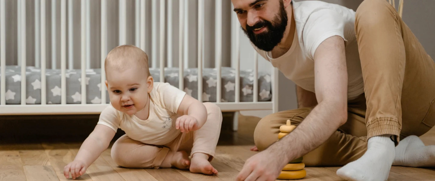 Tummy time for newborns with a parent supervising baby on the floor