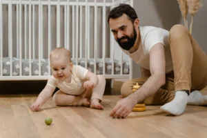 Tummy time for newborns with a parent supervising baby on the floor
