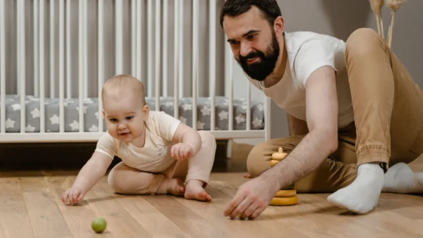 Tummy time for newborns with a parent supervising baby on the floor